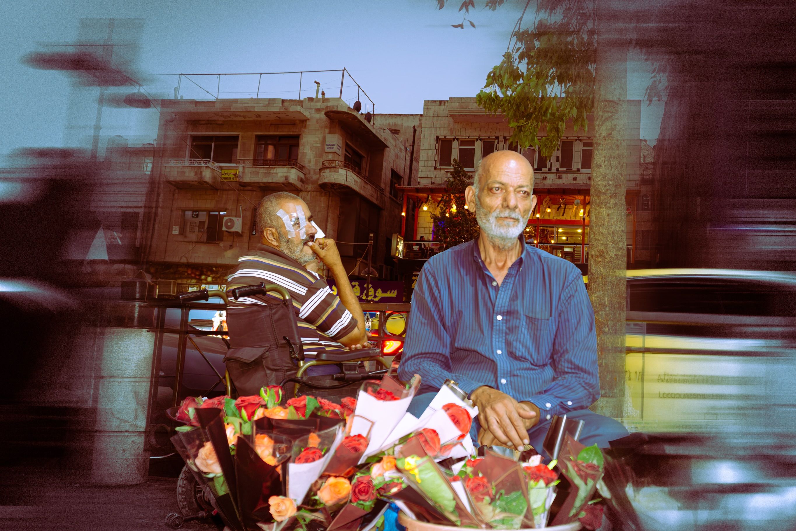 A street scene with an elderly flower seller surrounded by rose bouquets, a man in a wheelchair with a bandaged eye behind him, motion-blurred traffic passing and buildings double-exposed overhead.